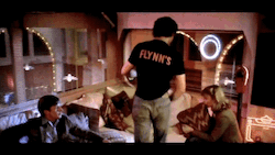 kevin flynn sits down on the couch and lora flings a pillow at his face