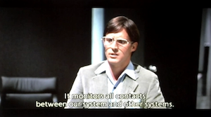 Alan Bradley in Dillinger's office, saying: It monitors all contacts between our system and other systems.