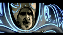 scene from TRON (1982) Tron and Yori approach the Input/Output Tower, which is guarded by Dumont in his extremely phallic outfit. Dumont asks: Who is your User, program? Tron replies, impatiently: Alan-1. He calls me. May I pass? Dumont begins to recite ritual words, and Tron assumes an odd ceremonial stance, hands clasped over his groin. Dumont continues: All that is visible must grow beyond itself, and extend into the realm of the invisible. You may pass, my friend