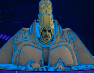 Dumont in his tower guardian outfit. He has a full beard and mustache. He is wearing a hat that looks almost exactly like a dick, but he still looks like less of a dickhead than Leto.