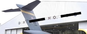 the top image of a plane entering a hangar that does not have enough room for its tail, but edited with blackout bars over the signage on the hangar so that it appears to say only "OH NO"