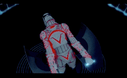 Sark, a humanoid computer program who wears a horned helmet. he is being tortured by the MCP, here appearing as a giant computerized face, seen from an angle which makes it look like the face is orally pleasuring Sark
